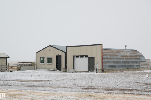 The property features a building with a light-colored exterior and a dark-colored roof - 114039 Range Road 221, Rural Lethbridge County, AB - Outdoor