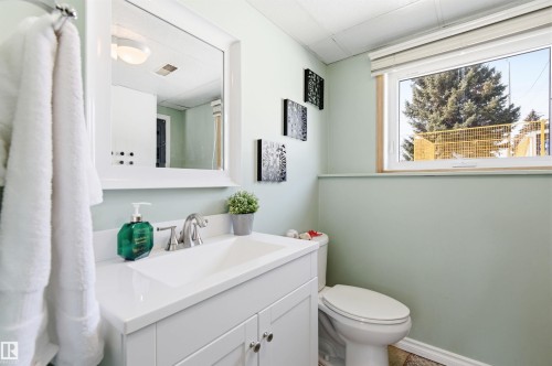 Bathroom featuring a white vanity with a rectangular sink and a window providing natural light - 12904 95 Street, Edmonton, AB - Indoor Photo Showing Bathroom