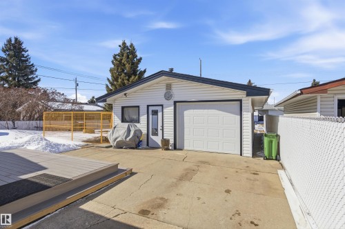 This property features a detached garage with a white overhead door and a separate entry door - 12904 95 Street, Edmonton, AB - Outdoor With Exterior