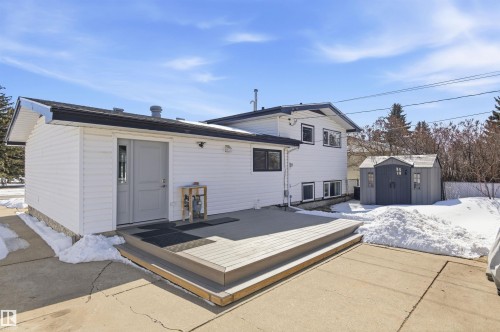 The property features a white exterior with black trim, a spacious deck, and a shed in the yard - 12904 95 Street, Edmonton, AB - Outdoor With Exterior