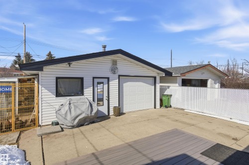 The property features a detached garage with white siding and a black roof, along with a white chain-link fence - 12904 95 Street, Edmonton, AB - Outdoor With Exterior