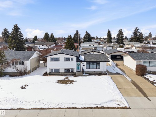 The property features a white exterior with black trim, a dark grey shingled roof, and an attached driveway - 12904 95 Street, Edmonton, AB - Outdoor With Facade