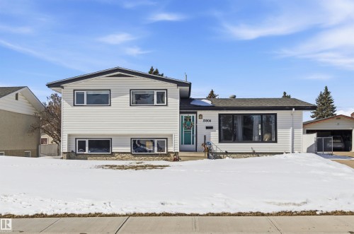 This property features white horizontal siding, dark window trim, and a turquoise front door - 12904 95 Street, Edmonton, AB - Outdoor With Facade
