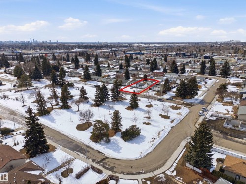 Aerial view showcasing the property situated within a neighborhood featuring mature trees and a distant cityscape - 12904 95 Street, Edmonton, AB - Outdoor With View