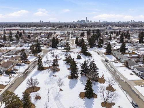 Aerial view showcasing surrounding residential properties with snow-covered grounds and a distant city skyline under a clear sky - 12904 95 Street, Edmonton, AB - Outdoor With View