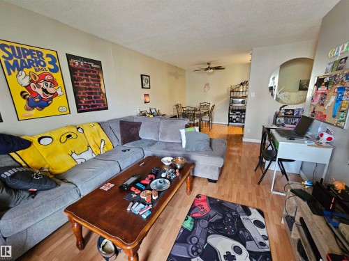 The property features light-toned walls and wood flooring throughout - 8 10616 123 Street, Edmonton, AB - Indoor Photo Showing Living Room