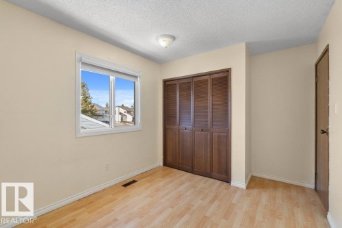 This room features light-colored walls, light wood flooring, and a window with a view of the surrounding area - 17313 60 Avenue, Edmonton, AB - Indoor Photo Showing Other Room