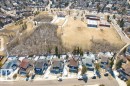 Overhead view of the property, showcasing its location within a residential neighborhood with surrounding parkland and a large building with a parking lot - 17313 60 Avenue, Edmonton, AB  - Outdoor With View 