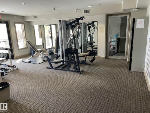 The property features a dedicated fitness area with various exercise machines, including weightlifting equipment and a bench - Edmonton, AB - Indoor Photo Showing Gym Room