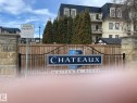 The property features a stone pillar entrance with visible address numbering, an ornate black metal gate, and a prominent sign for "The Chateaux at Whitemud Ridge" - Edmonton, AB  - Outdoor With Balcony 