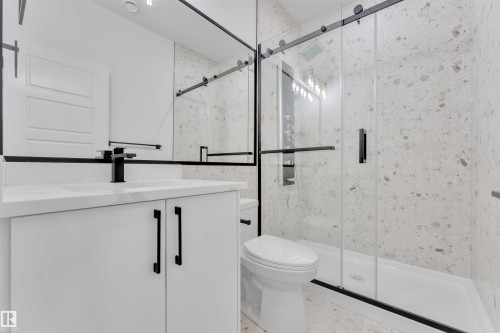 Bathroom featuring a white vanity with black hardware, a black-framed mirror, and a shower with a sliding glass door - 12 Dalquist Bay, Leduc, AB - Indoor Photo Showing Bathroom