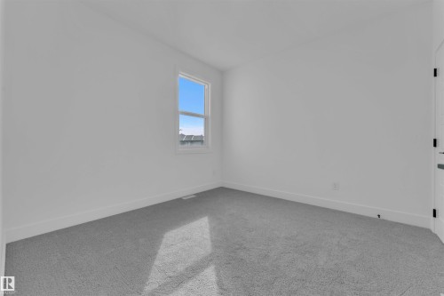 This room features light gray carpet flooring and a single window, providing natural light - 12 Dalquist Bay, Leduc, AB - Indoor Photo Showing Other Room