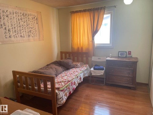 Room featuring wood-finish flooring, a single window with curtain rod, and light-toned walls - 9320 175 Street, Edmonton, AB - Indoor Photo Showing Bedroom