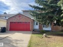 The property features a brick facade with a red garage door, a white front door, and a bay window - 9320 175 Street, Edmonton, AB  - Outdoor 