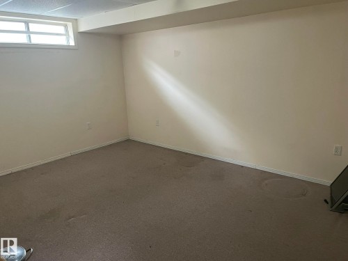 Room featuring neutral wall paint, gray carpeting, white baseboards, and a drop ceiling - 9320 175 Street, Edmonton, AB - Indoor Photo Showing Other Room