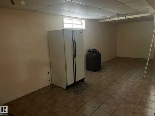 Lower-level room featuring neutral-toned tile flooring and light-colored walls - 9320 175 Street, Edmonton, AB - Indoor