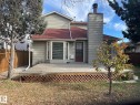 The property features a spacious deck with lattice detailing, a red roof, and a prominent chimney - 9320 175 Street, Edmonton, AB  - Outdoor With Deck Patio Veranda 