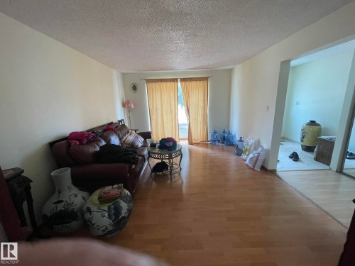 Spacious living area featuring wood-finish flooring, light-toned walls, and a textured ceiling - 9320 175 Street, Edmonton, AB - Indoor Photo Showing Living Room