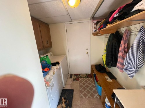 Utility room featuring tile flooring, built-in shelving, and upper cabinetry - 9320 175 Street, Edmonton, AB - Indoor