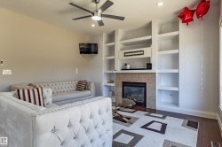 Living area featuring a ceiling fan with light, recessed lighting, and rich hardwood flooring - 