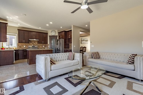 The property features an open-concept living area with a ceiling fan, a patterned area rug, and light-colored walls - 3611 14 Street, Edmonton, AB - Indoor Photo Showing Living Room