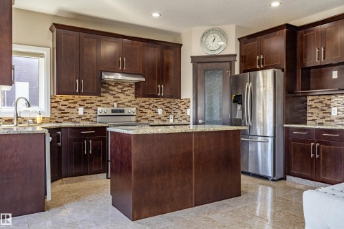 Kitchen featuring dark wood cabinetry, granite countertops, stainless steel appliances, and a tiled backsplash - 3611 14 Street, Edmonton, AB - Indoor Photo Showing Kitchen With Upgraded Kitchen