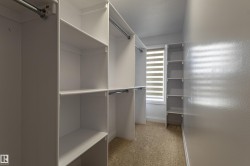 The property features a walk-in closet with built-in shelving, hanging rods, and a window with horizontal blinds - 