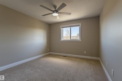 This room features a ceiling fan with light, a window providing natural light, and carpeted flooring - 