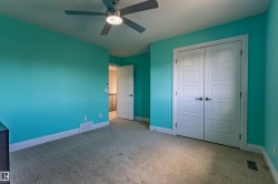 This room features carpeting, a ceiling fan, and double panel doors - 