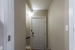 The property features a white paneled door with dark hardware and light-colored walls - 