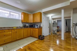 This space features wood cabinetry with a countertop, a sink, and a window - 