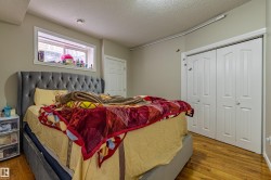 This room features wood flooring, a window with white trim, and white bi-fold closet doors - 