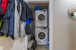 Laundry area featuring a stacked washer and dryer unit - 