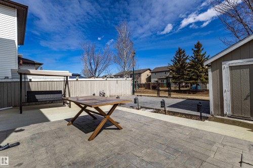 The property features an extensive stamped concrete patio, a wooden fence, and a storage shed - 3611 14 Street, Edmonton, AB - Outdoor
