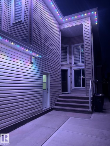 Property exterior featuring horizontal siding, a white entry door, and concrete steps leading to the main entrance - 3611 14 Street, Edmonton, AB - Indoor Photo Showing Other Room