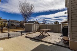 The property features a fenced yard with a shed, a patio area, and an exterior wall with horizontal siding - 