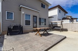 The property features a patio with stone pavers, a wooden privacy fence, and vinyl siding - 