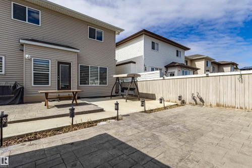 The property features an extensive backyard with a paved patio area, a privacy fence, and an additional concrete patio space directly outside the home - 3611 14 Street, Edmonton, AB - Outdoor With Exterior