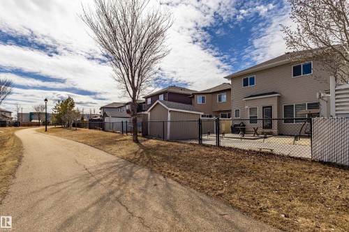 The property features a fenced backyard with a patio area and direct access to a paved pathway - 3611 14 Street, Edmonton, AB - Outdoor