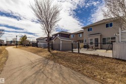 The property features a fenced backyard with a patio area and direct access to a paved pathway - 