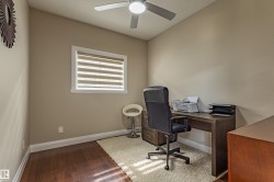 This room features hardwood floors, a window with blinds, and a ceiling fan - 