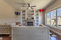 Living area featuring hardwood flooring, a ceiling fan, recessed lighting, and a large window providing natural light - 