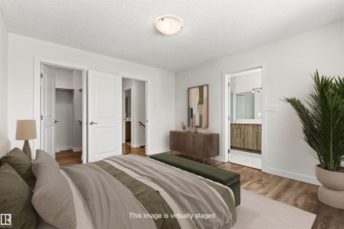 The bedroom features hardwood style flooring, white walls, and a ceiling light fixture - 3668 31A Street, Edmonton, AB - Indoor Photo Showing Bedroom