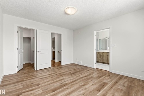 This bright room features light-toned wood-style flooring and white walls, creating a clean aesthetic - 3668 31A Street, Edmonton, AB - Indoor Photo Showing Other Room