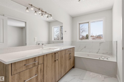 Bathroom featuring a spacious vanity with light wood cabinetry, a white countertop, and a built-in sink - 3668 31A Street, Edmonton, AB - Indoor Photo Showing Bathroom