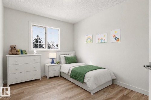 This property features a room with light wood-tone flooring, a window offering views of trees, and neutral-toned walls - 3668 31A Street, Edmonton, AB - Indoor Photo Showing Bedroom