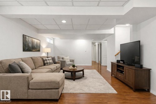 Spacious living area featuring warm wood flooring, recessed lighting, and a window - 3668 31A Street, Edmonton, AB - Indoor Photo Showing Living Room