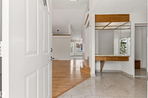 The property features a bright entrance with a white front door, leading to an interior with both tiled flooring and hardwood floors - 3668 31A Street, Edmonton, AB - Indoor Photo Showing Other Room
