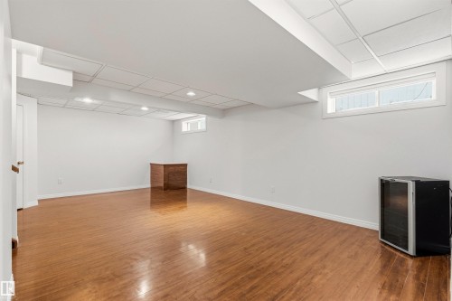 This spacious room features light wood flooring, white walls, and a drop ceiling with recessed lighting - 3668 31A Street, Edmonton, AB - Indoor Photo Showing Basement