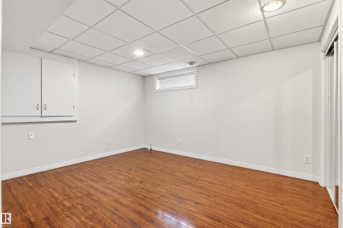 This room features rich wood flooring, white walls, and a dropped ceiling with recessed lighting - 3668 31A Street, Edmonton, AB - Indoor Photo Showing Other Room